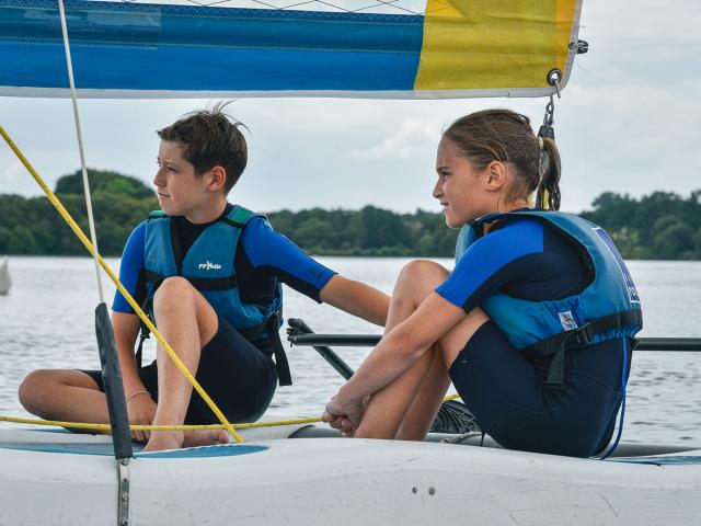 Deux jeunes adolescent font du catamaran