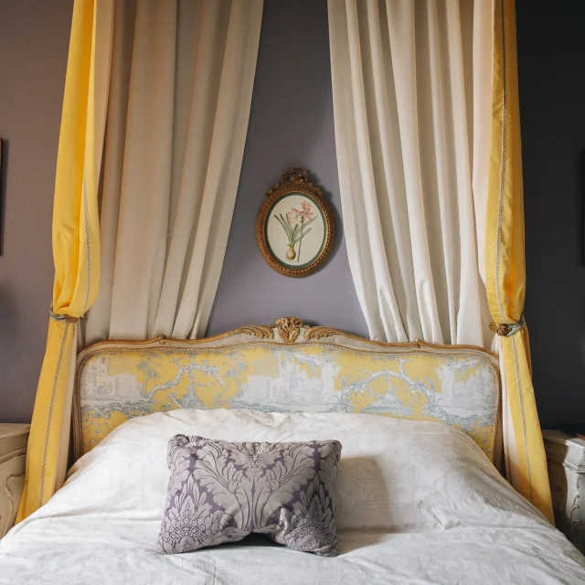 Chambres d'Hôte La Maison d'Hercule. Une jolie chambre décorée dans les tons de jaune avec un ciel de lit à l'ancienne
